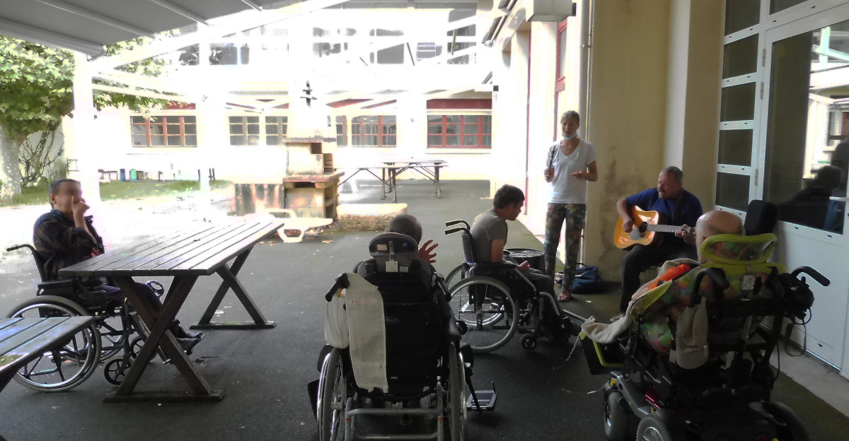 Le duo Palenka joue à l'extérieur du pavillon Camino à l'hôpital marin de hendaye, 4 patients (vus de dos) écoutent et réagissent aux musiques variées