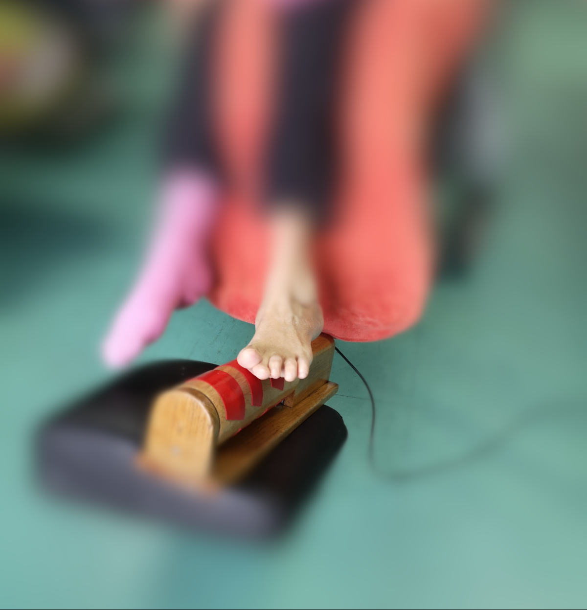 deux pieds d'une personne handicapée dont avec l'aide d'un pied elle fait tourner un rouleau pour produire de la musique, procédé de l'orgue sensoriel