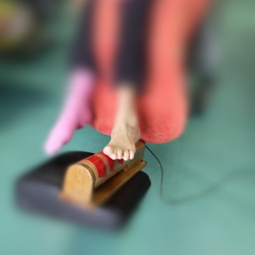 deux pieds d'une personne handicapée dont avec l'aide d'un pied elle fait tourner un rouleau pour produire de la musique, procédé de l'orgue sensoriel