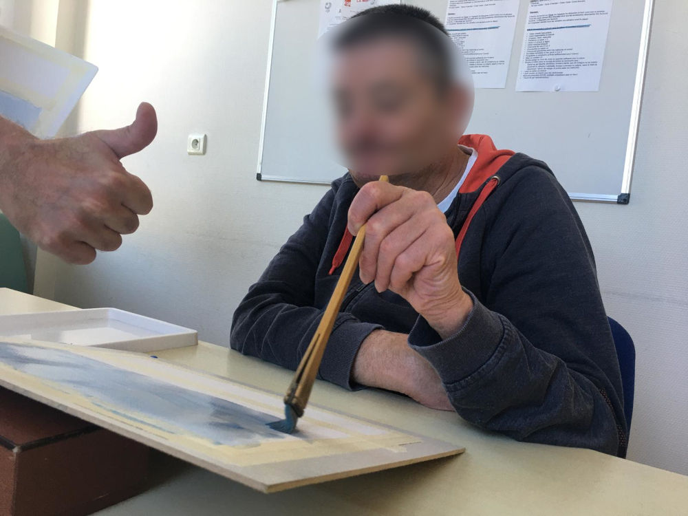 un patient (flouté) qui peint