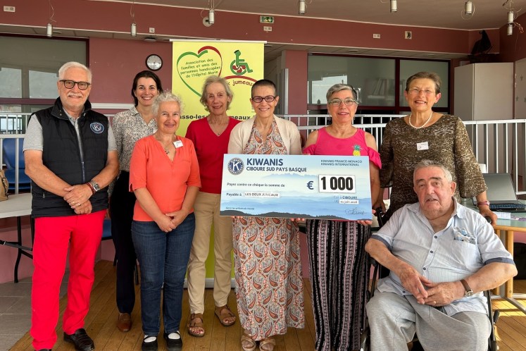 8 personnes posent avec un grand chèque de 1000€ des Kiwanis